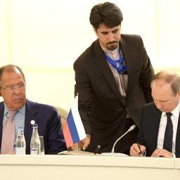 Владимир Путин подписывает трехстороннюю декларацию. Слева – министр иностранных дел РФ Сергей Лавров. Фото пресс-службы Кремля