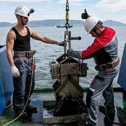 Никита СЕЛИВЁРСТОВ и руководитель Отряда морской геологии Андрей ЯЦУК (старший научный сотрудник Лаборатории системного контроля за глобальными изменениями климата ИМО ДВФУ и Лаборатории газогеохимии ТОИ ДВО РАН) работают с бокс-корером (пробоотборником). Фото предоставлено Институтом Мирового океана ДВФУ 