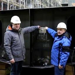 Директор РК «Вирма» Иван ПАСЫНКОВ и гендиректор Северной верфи Игорь ПОНОМАРЕВ опускают закладную доску в специальный карман. Фото пресс-службы завода